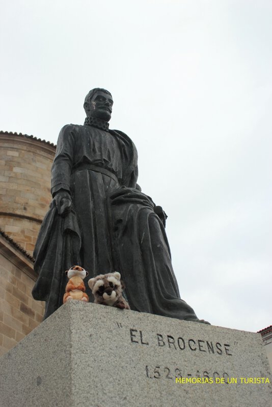 Mery y Pepe con El Brocense situado al lado de la iglesia