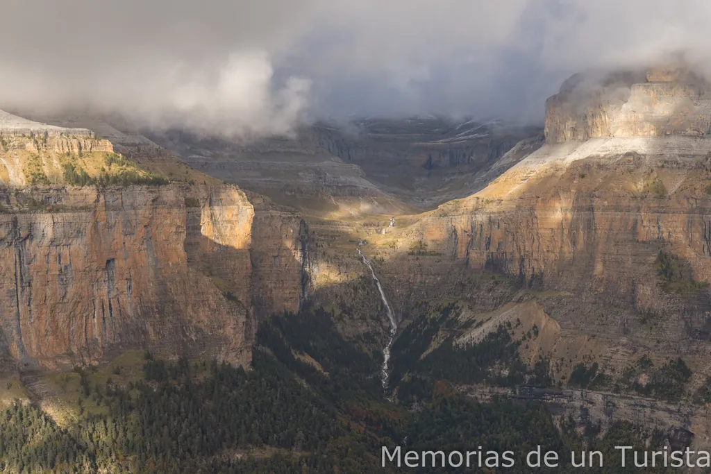 Panorámica de los Pirineos desde los miradores de Ordesa, por encima de la Faja de Pelay, con la cascada de Cotatuero y las grandes paredes del cañón iluminadas por rayos de sol entre nubes
